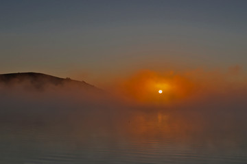 sunrise on a lake with evaporation of water