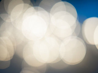 Beautiful blurred bokeh light yellow on a blue background. Christmas concept.