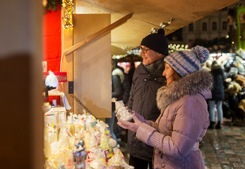 shopping, winter holidays and people concept - happy senior couple at christmas market souvenir...