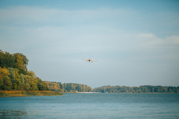 Photo of autumn forest, lake, flying plane
