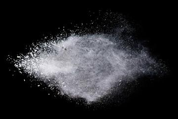 Freeze motion of white color powder exploding on dark background. 