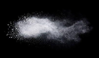 Freeze motion of white color powder exploding on dark background. 