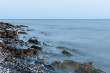 Fototapeta na wymiar large stones on the shore of the evening sea