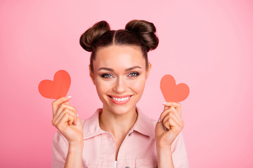 Portrait of charming lady holding papercard heart looking smiling wearing jacket isolated over pink background