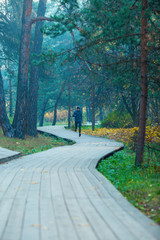 Image of running athlete in autumn park.