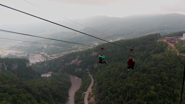 Sochi, Russia - may 2019. Two womans fly on zipline in Sochi Skypark. Slow motion