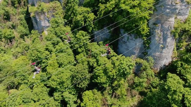 Sochi, Russia - may 2019. Drone view three people riding on zipline in Sochi Skypark. Green summer landscape.