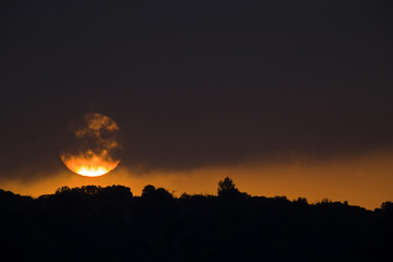 The sun rising early in the morning above the hills of the Algarve Portugal.