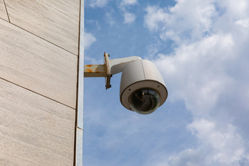 Overhead security camera on public building or office centre facade.