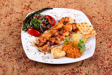 Chicken Kebab Chicken Serving with Fresh Berries and Vegetables on a White Plate on a Table Filled with Close-Up Fragrant Spices