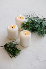Fototapeta na wymiar White Candles. Christmas mood. Flaming candles on table.
