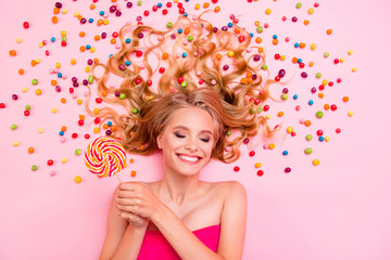 Obraz na płótnie Canvas Vertical side profile top above high angle view photo she her lady lying down sweets ideal hair chocolate colored little candies arms hands lolly pop eyes closed imagination isolated pink background