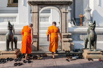 Buddyjscy mnisi zdejmują buty aby wejść do świątyni