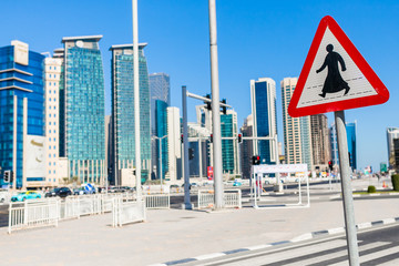 Znak przejście dla pieszych na tle wieżowców w Qatarze, znak w kraju arabskim
