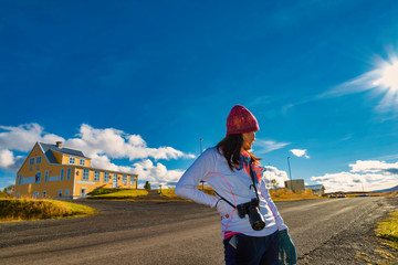 A traveler woman walking on the street for sightseeing the typical Icelandic landscape with houses and beautiful blue sky background, Iceland - 290109830