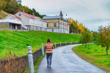 A traveler woman walking on the street for sightseeing, beautiful perspective view in Akureyri, Iceland - 290110072