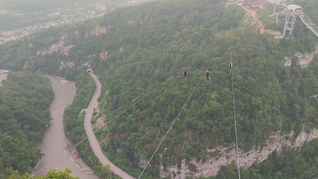 Sochi, Russia - may 2019. Three Chinese girls flying on zipline and waving in SkyPark Sochi