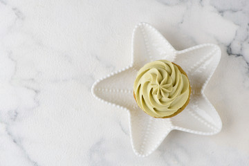 green matcha cupcake on white star plate