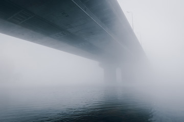 Bridge over foggy river Dnipro at early autumn morning. Kiev. Ukraine.