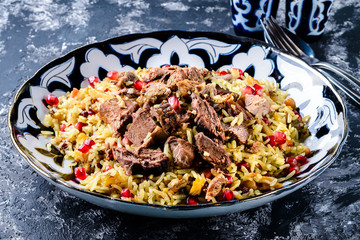 Uzbek pilaf Rice with Meat and Vegetables. Garnished with Onions and Tomatoes Salad