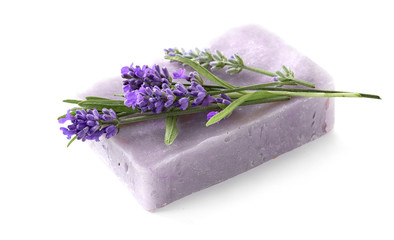 Homemade lavender soap bar with lavender flowers atop isolated on white.