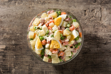 Traditional Russian salad for Christmas. Olivier salad on wooden table. Top  view