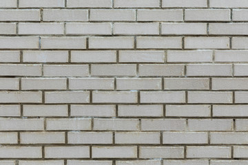 Front view of gray cement wall tiled with brick.