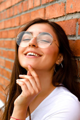 young girl on a background of a red brick wall. Portrait. White shirt