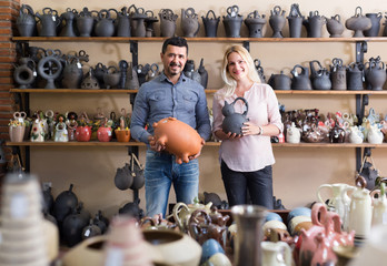 Fototapeta na wymiar portrait of man and woman shopping ceramic utensil in boutique
