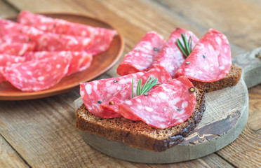 Sandwiches with salami on the wooden board
