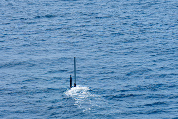 Real periscope and radio transmission mast of the attack submarine  during the submarine sails in...