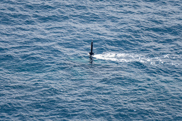 Real periscope and radio transmission mast of the attack submarine  during the submarine sails in the periscope depth in the sea