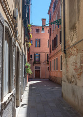 Fototapeta na wymiar Narrow street with historic houses in Venice, Italy, in a beautiful sunny day.