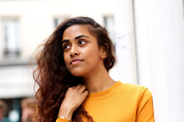 Close up beautiful young indian woman with piercing looking away