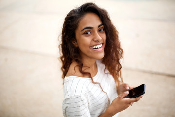 side portrait of attractive young indian woman with cellphone