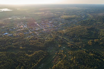 Aerial photography with a drone. Village with green forest, road and lake