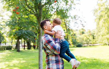 Fototapeta premium family, fatherhood and people concept - happy father with little son in summer park