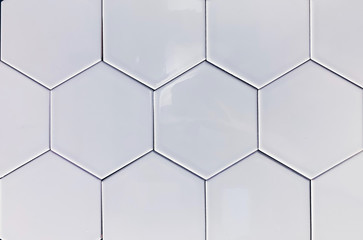 real photo of glossy white hexagonal tiles wall on black background isolated. geometric pattern,...