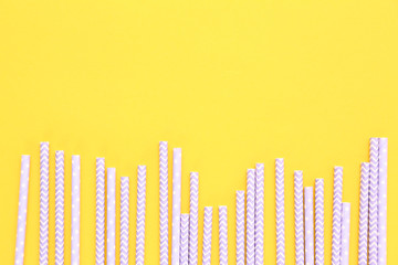 Paper straws on yellow background