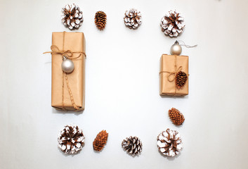 Christmas holidays composition on silver paper background. Craft boxes of gifts, wooden deer and snowflakes, fir cones, pine cones. Concept of happy (marry) christmas card.
