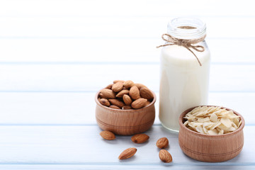 Almond and milk in bottle on wooden table