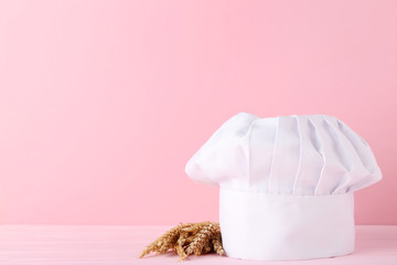 Chef hat with wheat ears on pink background