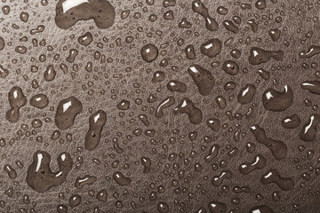Rain droplets on brown glass background, Water drops on blue glass.