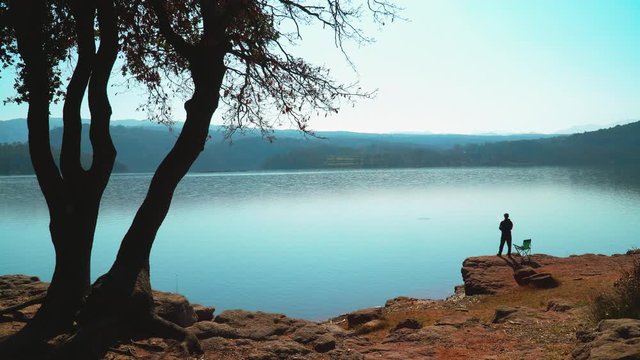A man fishing on the banks of a lake