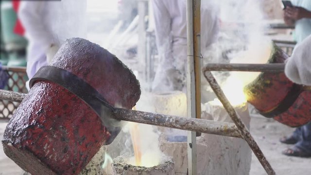 Artisan working gold melting process. Molted metal pouring into bar form.Solids that have undergone high heat treatment for melting according to the model.Foundry.