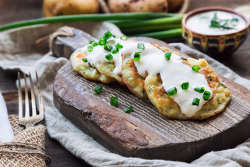 Potato pancakes with dill on rustic wooden cutting board
