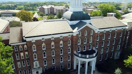 AERIAL Flyover of brick academic and dormitory buildings on college campus, university setting in Pennsylvania