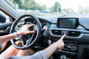 Close-up, female hand includes an emergency stop button, turning on dimensions, accident on road. The interior of car in summer in city, an alarm and accidents on highway.