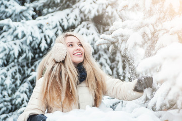Smiling beautiful woman has fun outdoors with snow. Winter Holidays concept.