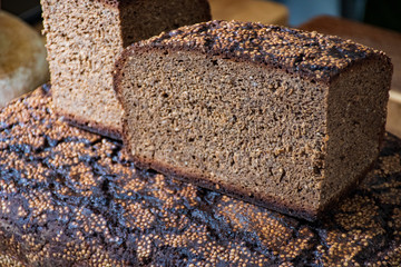Homemade black rye cereal bread with hemp seeds in a traditional street food market 